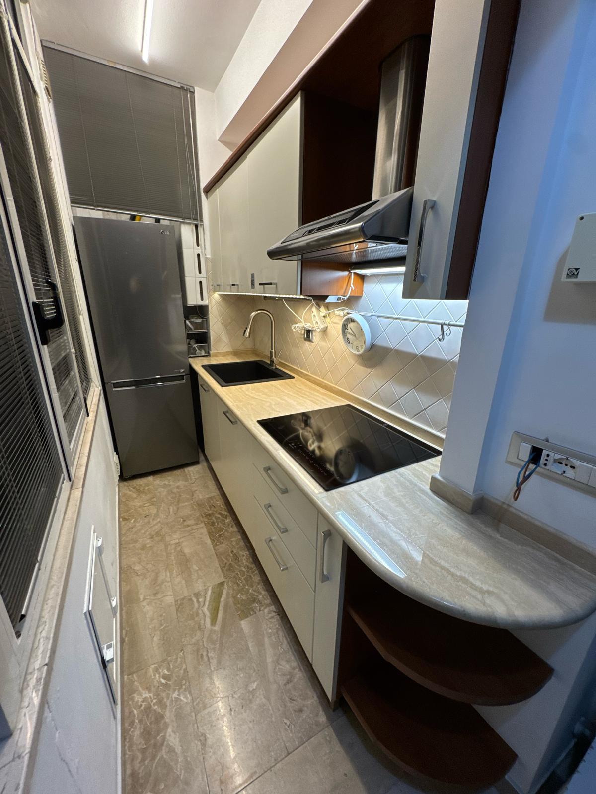 Full kitchen with Travertine top and rounded peninsula
