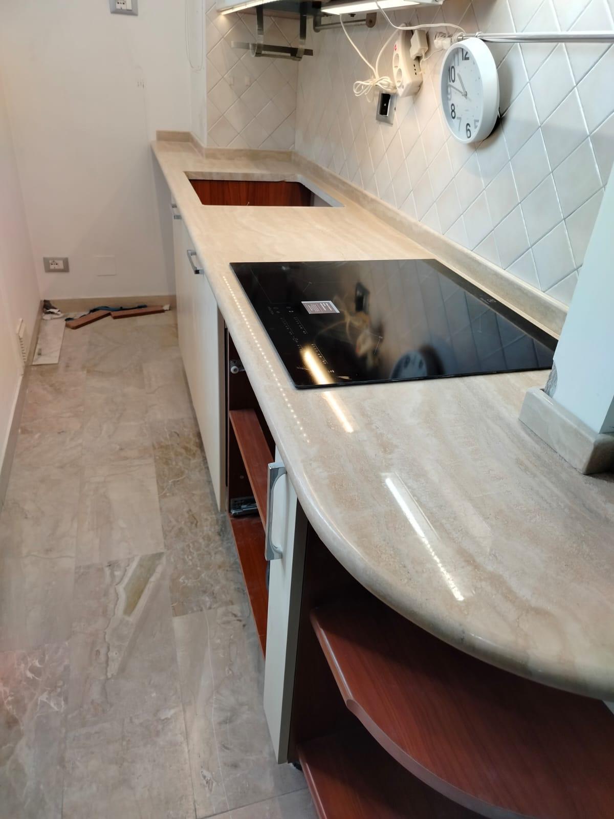 Travertine kitchen counter with rounded peninsula