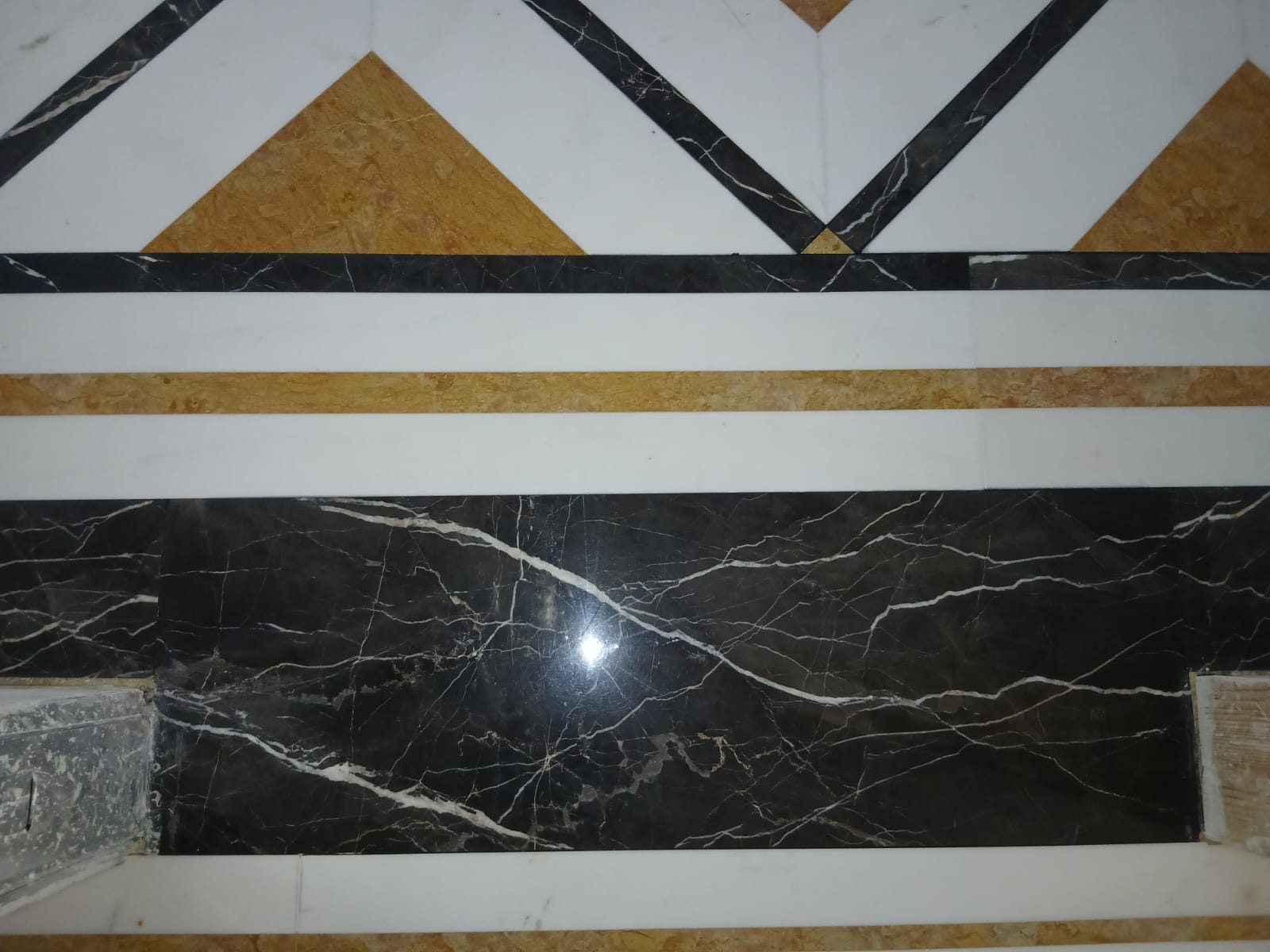 Floor band in mixed marbles: white, ochre and veined black